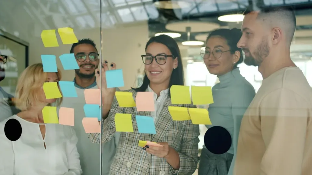 Casos reales de webs optimizadas para motores generativos 1 Team collaborating with sticky notes on glass wall